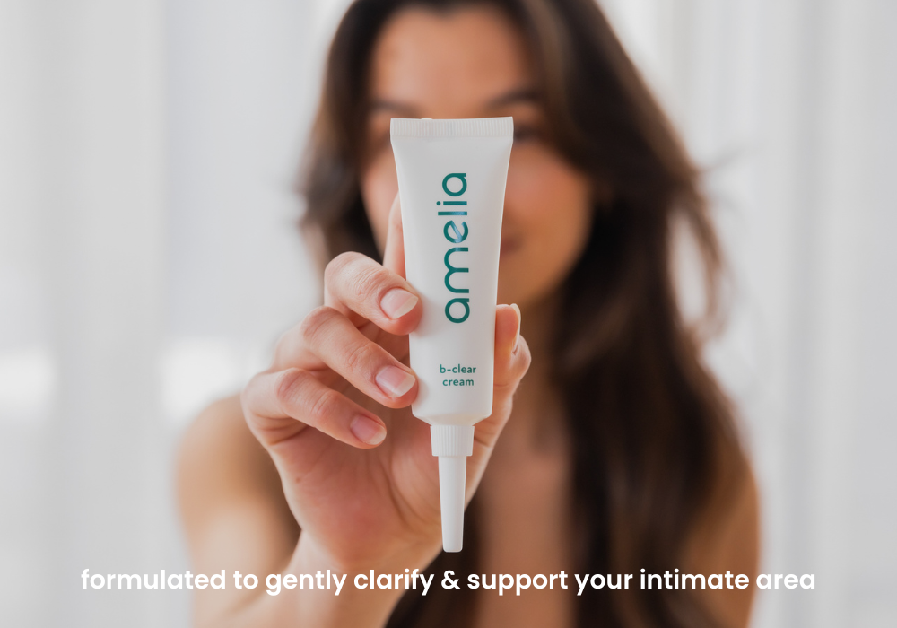 Person holding a tube of 'amelia' cream with a blurred background